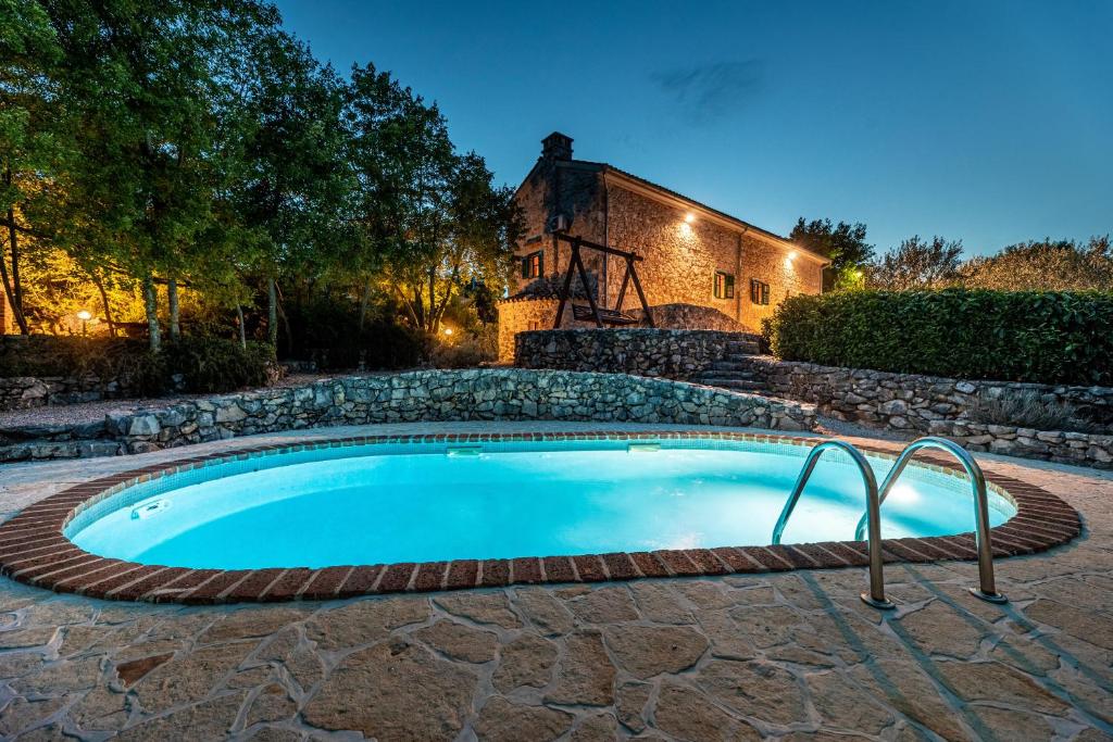 een zwembad voor een huis met een gebouw bij Villa Lindraze in Dobrinj
