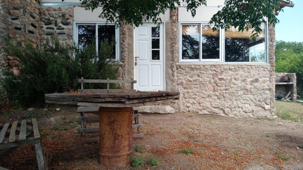 a stone house with a bench in front of it at Cabañas La Rústica in Bialet Massé