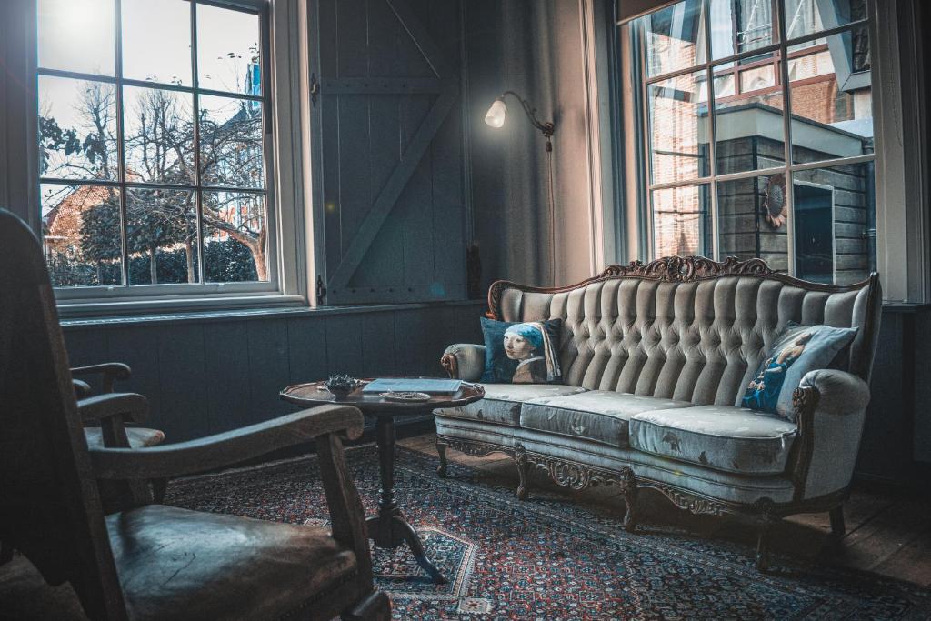 een woonkamer met een bank en een tafel bij Bed en kerk monumentale 2 slaapkamer woning in Hoorn