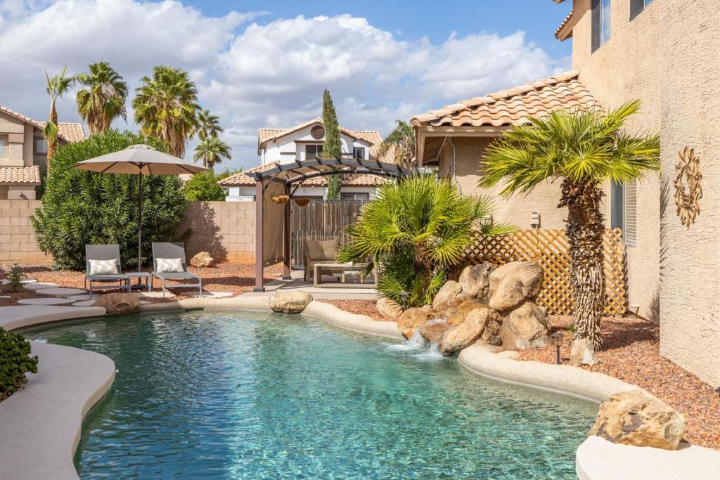 a swimming pool with a waterfall in a yard at Gilbert Douglas home in Gilbert