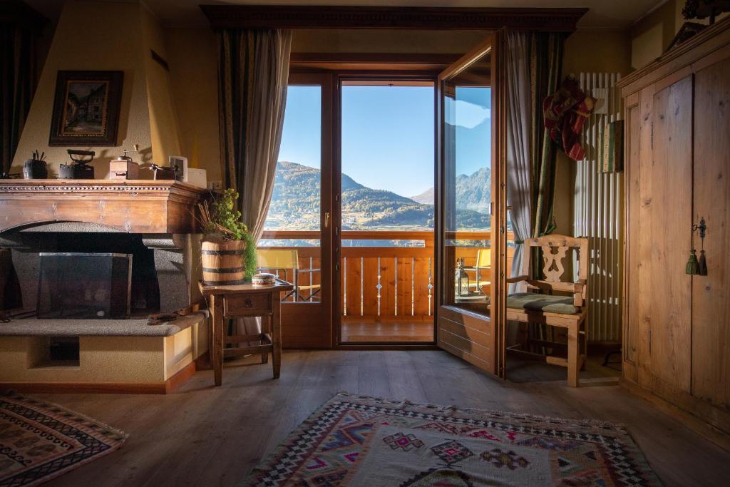 a living room with a fireplace and a view of a mountain at Chalet Casericc in Bormio
