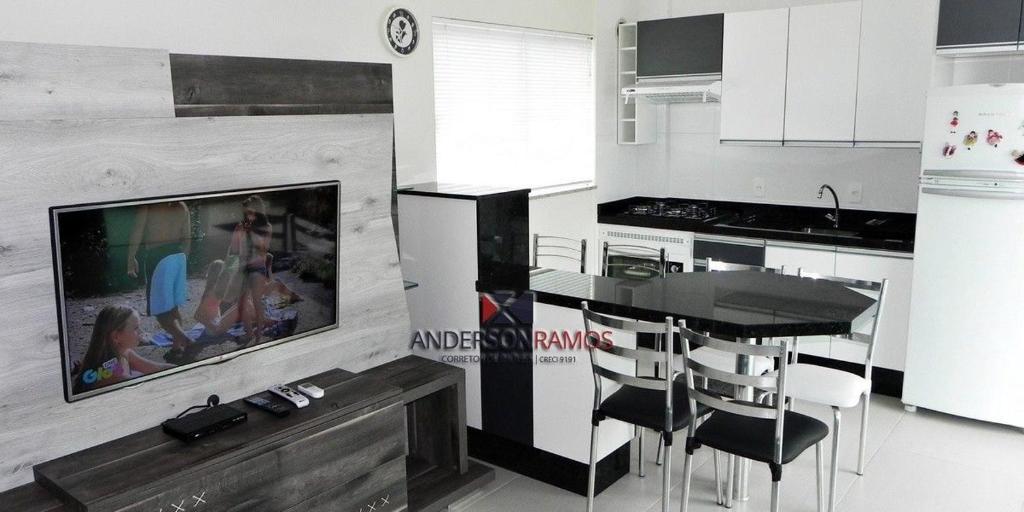 cocina con TV, mesa y sillas en 1022 - Apartamento com vista para o mar de Bombinhas - Residencial Areia Branca Apto 301, en Bombinhas