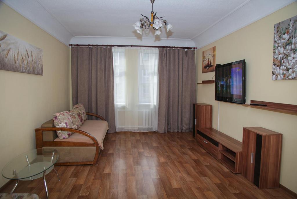 een woonkamer met een bank en een tv bij Apartments on Gogolya, 14a in Dnipro