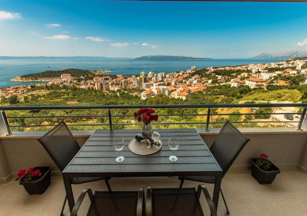 a table on a balcony with a view of the city at Seaview apartments Oscar in Makarska