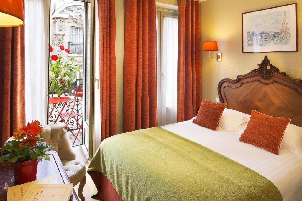a hotel room with a bed and a balcony at New Orient Hotel in Paris
