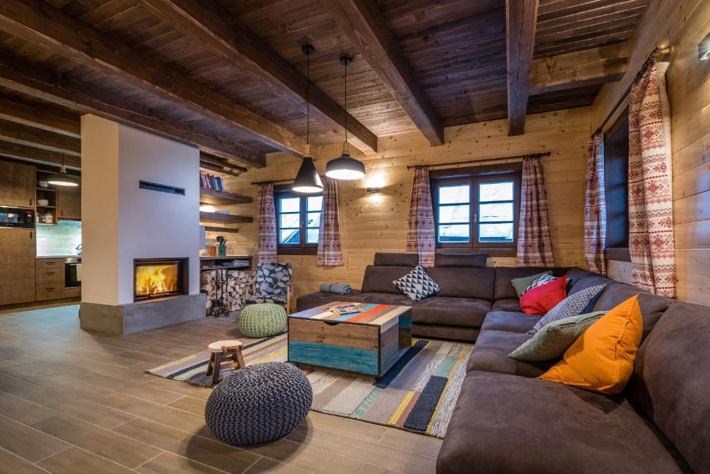 a living room with a couch and a fireplace at Drevenica Emilka - Sprcha, Záhradná hojdačka, Ohnisko in Brezno