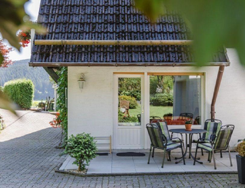 eine Terrasse mit einem Tisch und Stühlen vor einem Gebäude in der Unterkunft Haus am Sonnenhang Typ B in Niedersalwey