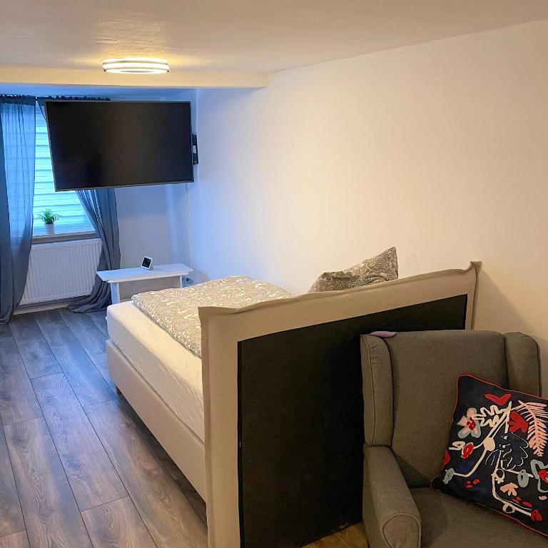 a small bedroom with a bed and a couch at Fernweh Harz in Seesen
