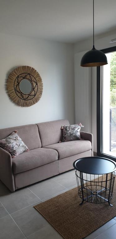 sala de estar con sofá y mesa en Très beau T2 au coeur de la citée thermale en Châtel-Guyon