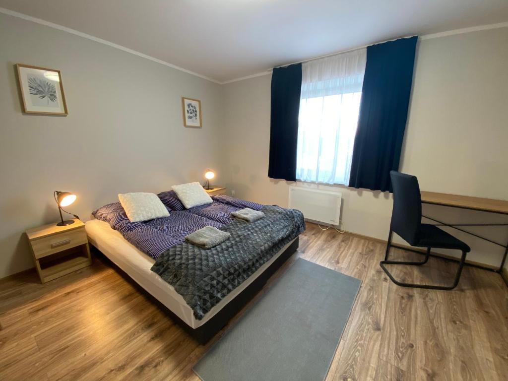 a bedroom with a bed and a chair and a window at Hotelik Nad Zalewem 10 km od Legnicy in Legnica