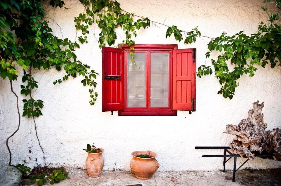 una ventana roja en el lateral de un edificio con dos ollas en B&b Parco Alta Murgia, en Cassano delle Murge