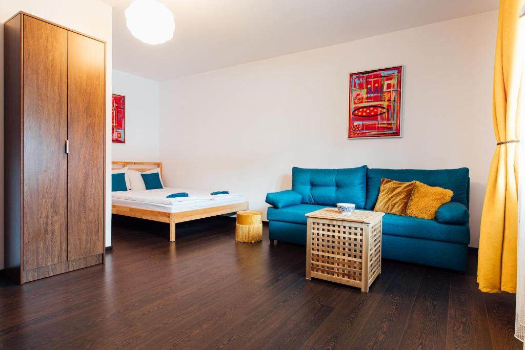 - un salon avec un canapé bleu et une table dans l'établissement Szitas Rooms, à Praid