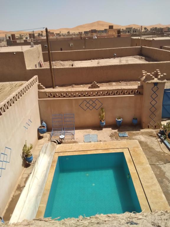 a swimming pool on the roof of a building at Maison Mirage B&B in Hassilabied