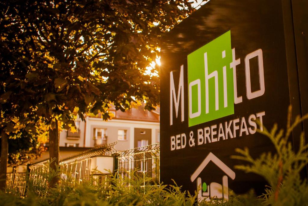 un cartel para un bed and breakfast frente a una casa en Mohito Bed&Breakfast, en Łomża