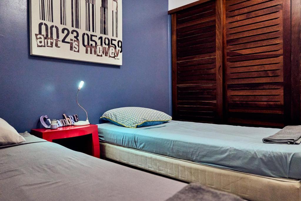 1 dormitorio con 2 camas individuales y mesa roja en Eden blue mer et piscine, en Sainte-Anne