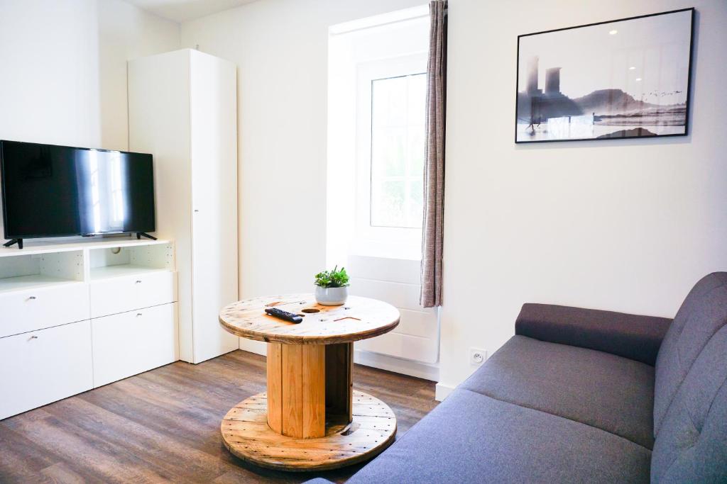uma sala de estar com um sofá e uma mesa em Les studios propres et tout équipés em Brest