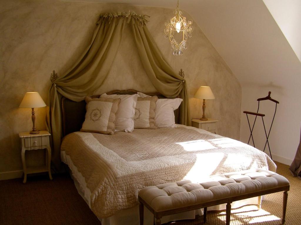 a bedroom with a large bed with a canopy at L'ange est rêveur in Langeais