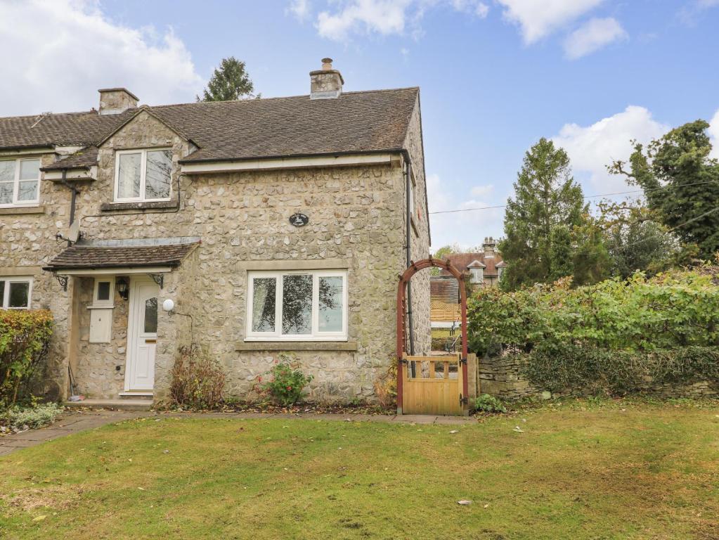 an old stone house with a wooden door at Cloud View Cottage in Ashbourne