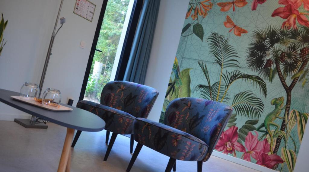 Zimmer mit Stühlen, einem Tisch und einem Fenster in der Unterkunft B&B Altijd Zomer in Nijlen
