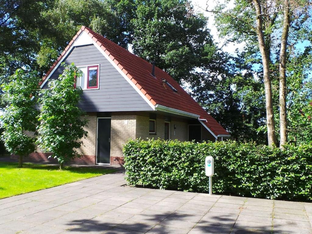 una casa con techo rojo y parquímetro en Fine vacation home near Lemelerberg, en Lemele