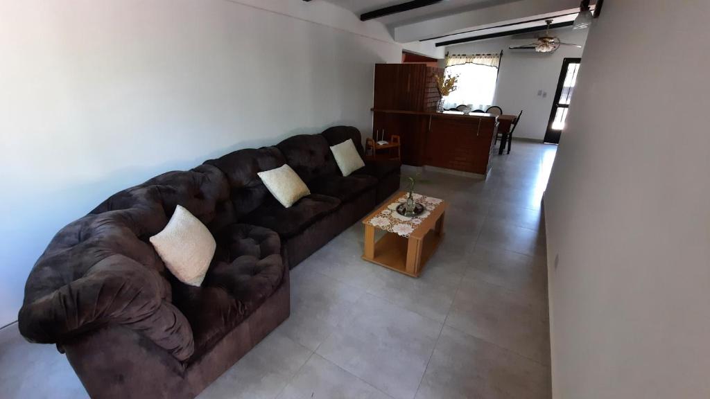 ein Wohnzimmer mit einem braunen Sofa und einem Tisch in der Unterkunft Casa Las Cinco Rosas in San Rafael