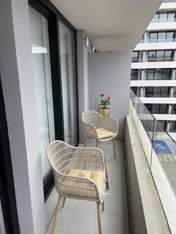 uma varanda com 2 cadeiras e uma mesa em Edificio Curitiba, Apartamento nuevo y céntrico 1B 1D em Temuco