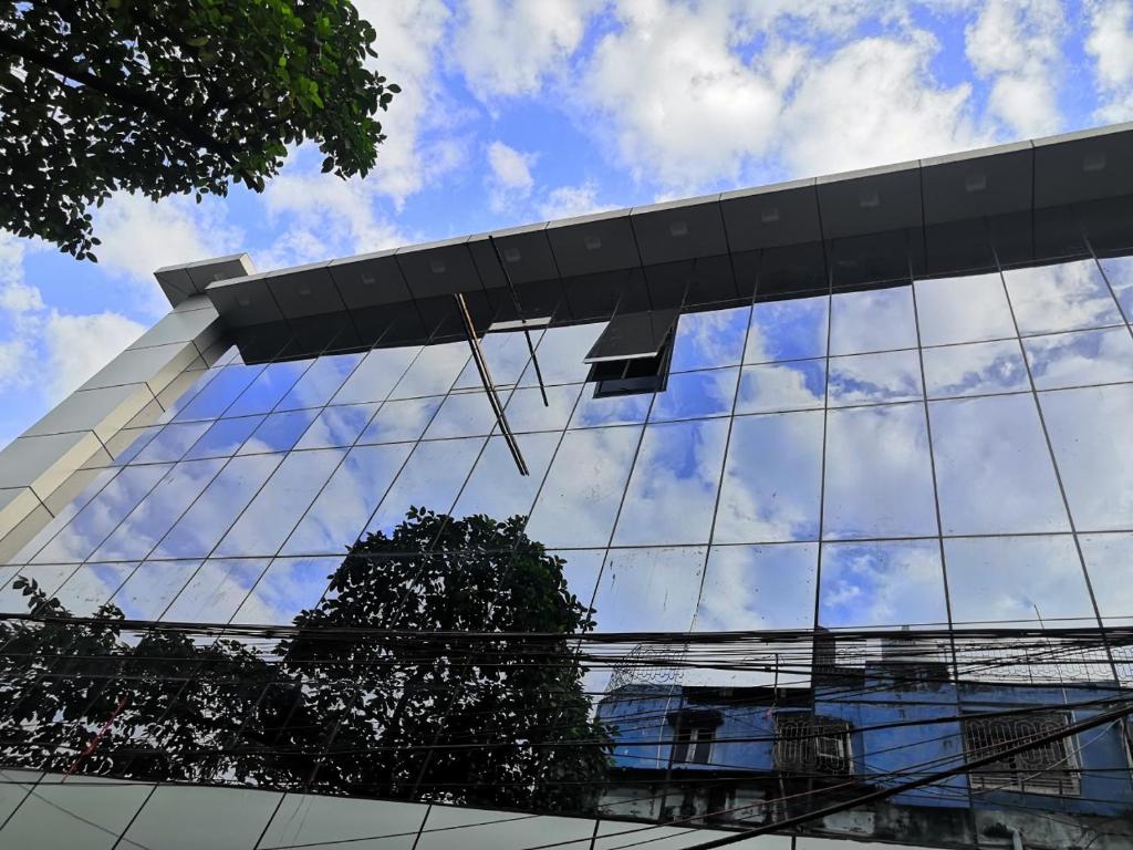 a reflection of the sky in the windows of a building at Astoria Hotel in Kolkata