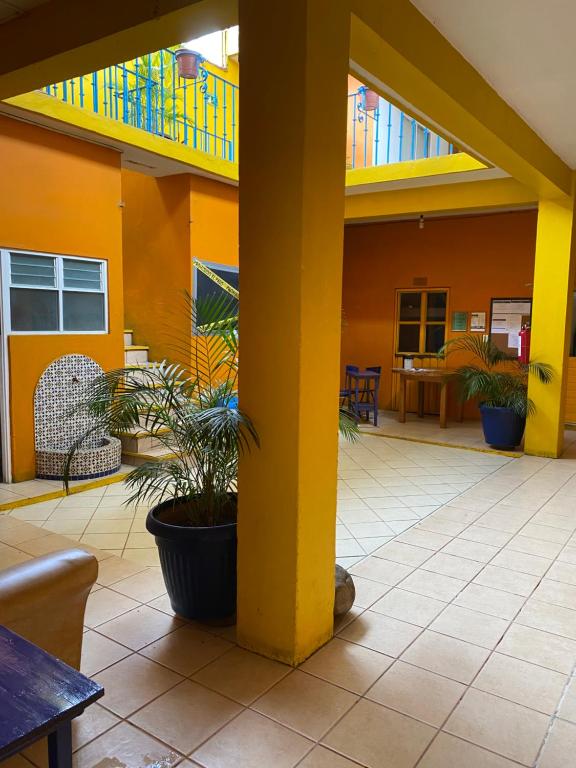 a building with a yellow pillar and a patio at Hostal Zipolite Arteaga in Oaxaca City