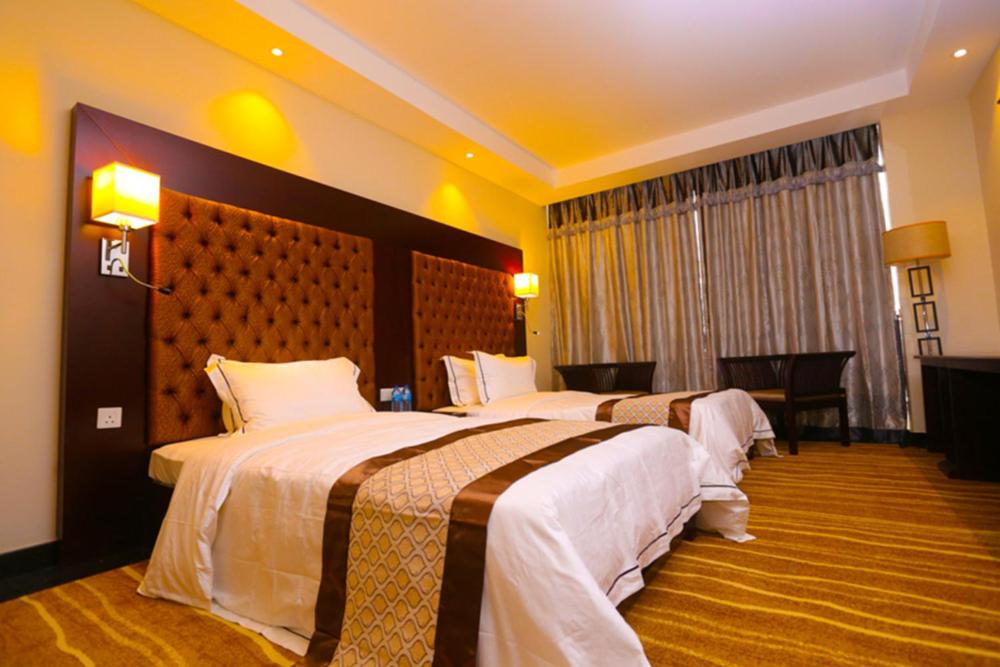 una habitación de hotel con 2 camas en una habitación en The Grand Mountain Hotel, en Matale