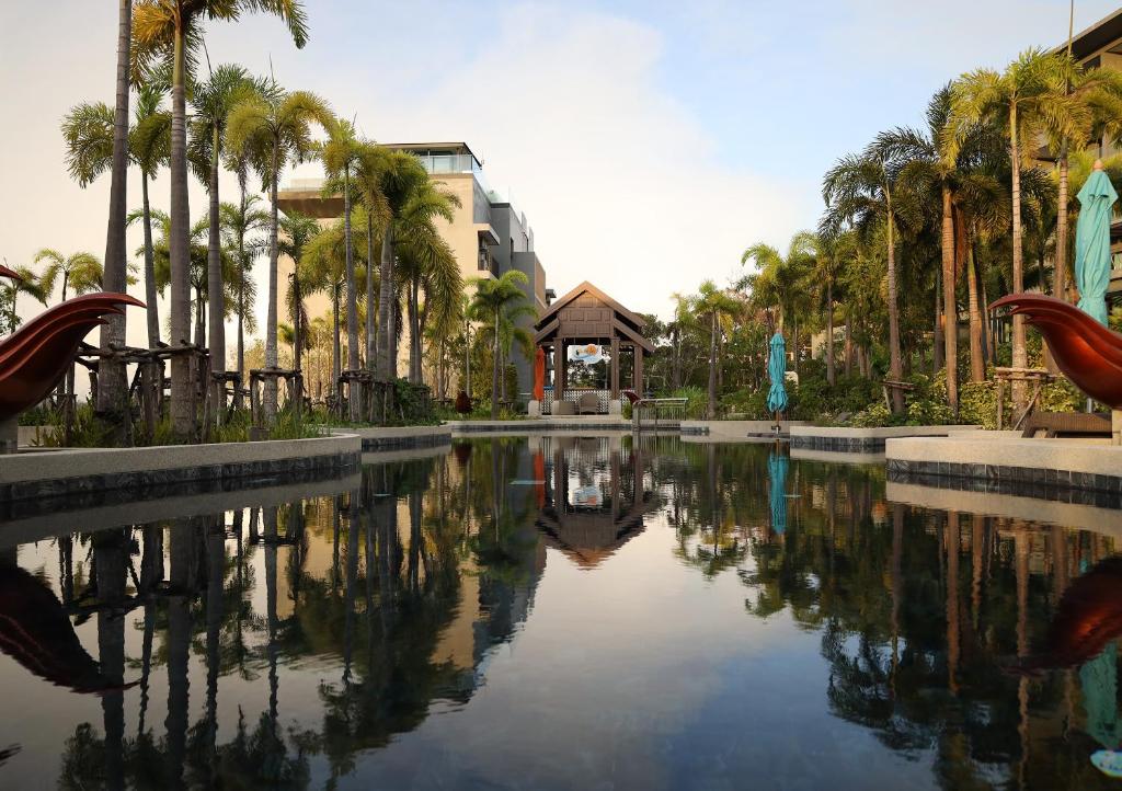 uma piscina de água com palmeiras e um edifício em Two Bedrooms Seaview Apartment Surin Bangtao Area 4407 em Ban Lum Fuang