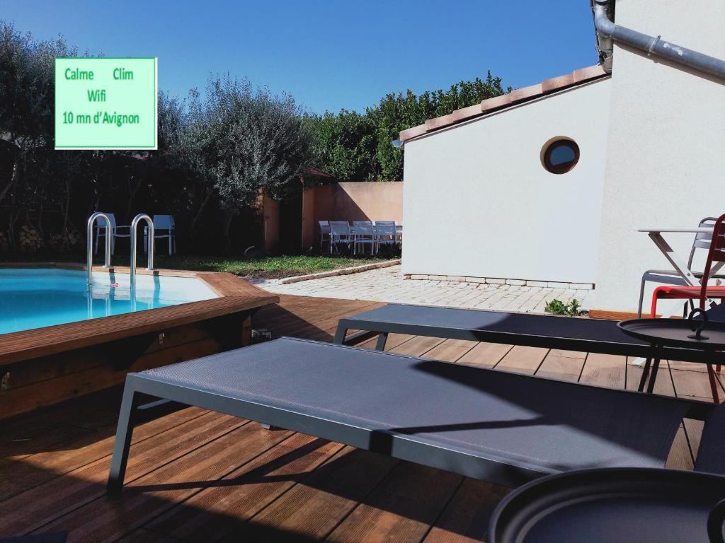 een zwembad met een tafel en stoelen op een terras bij Villa Les oliviers in Le Pontet