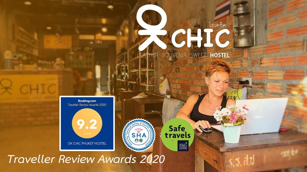 a woman sitting at a table with a laptop at OK CHIC PHUKET HOSTEL in Phuket