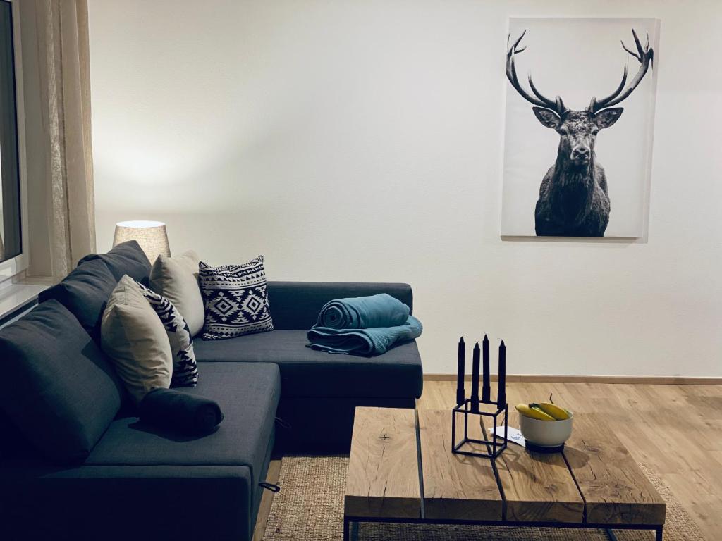 a living room with a couch and a deer picture on the wall at cozy3 am Europa Park in Ettenheim