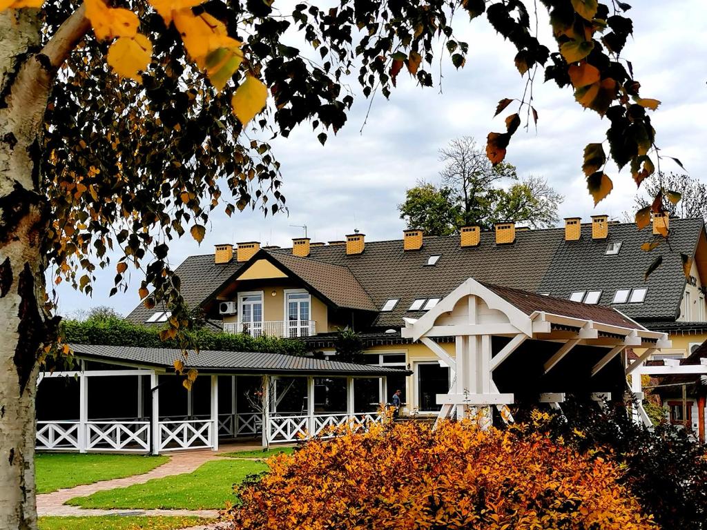 a house with a black roof and a yard at Zajazd Podzamcze in Fałków