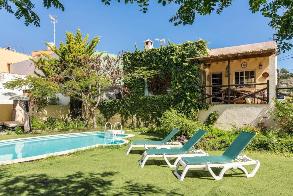 a yard with two lounge chairs and a swimming pool at La Alpispa in San Francisco de Paula