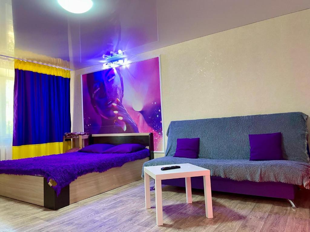 a room with a bed and a couch and a table at Квартира в центре (р-н Аян Пассаж) in Temirtaū