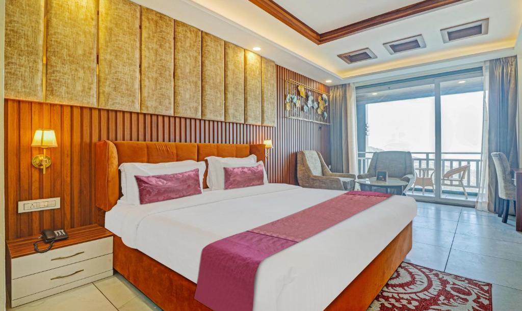 ein Schlafzimmer mit einem großen Bett und einem Balkon in der Unterkunft Hotel Woodville Inn Mcleodganj in McLeod Ganj