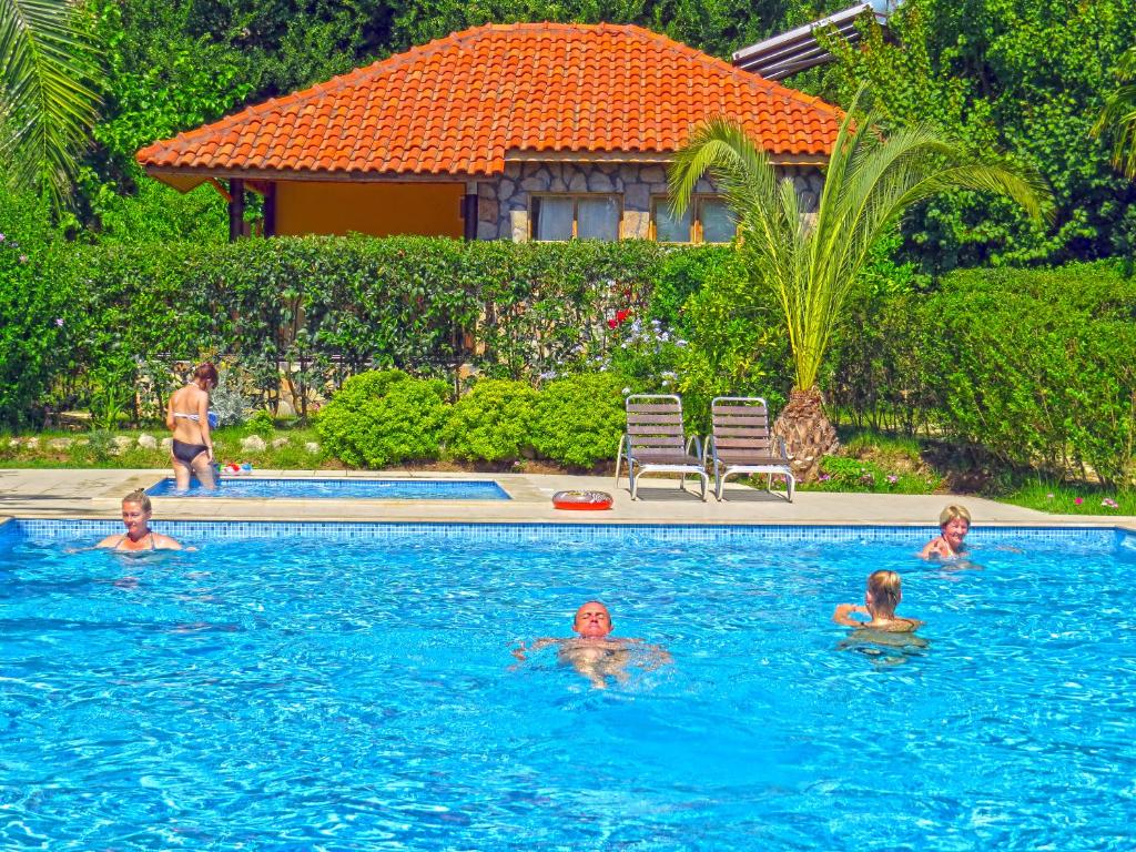 a group of people swimming in a swimming pool at Cirali Hotel in Cıralı