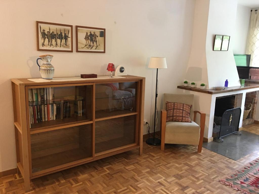 埃斯波特的住宿－Apartament familiar - Els Encantats - Espot，客厅设有书架和椅子
