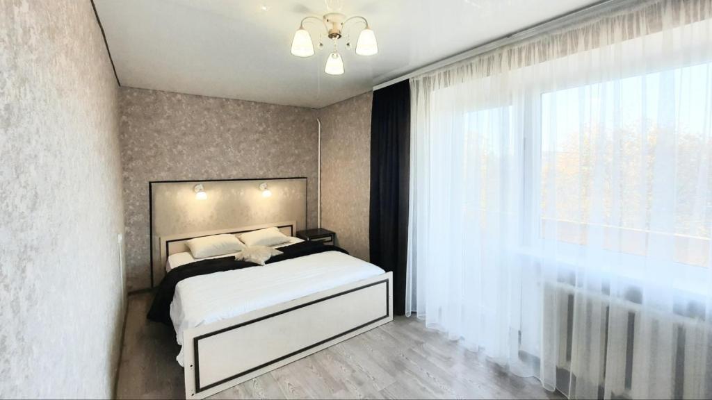um quarto com uma cama branca e uma janela em Двухкомнатная квартира 500м от моря ул Парковая отчетные док em Chornomorsk