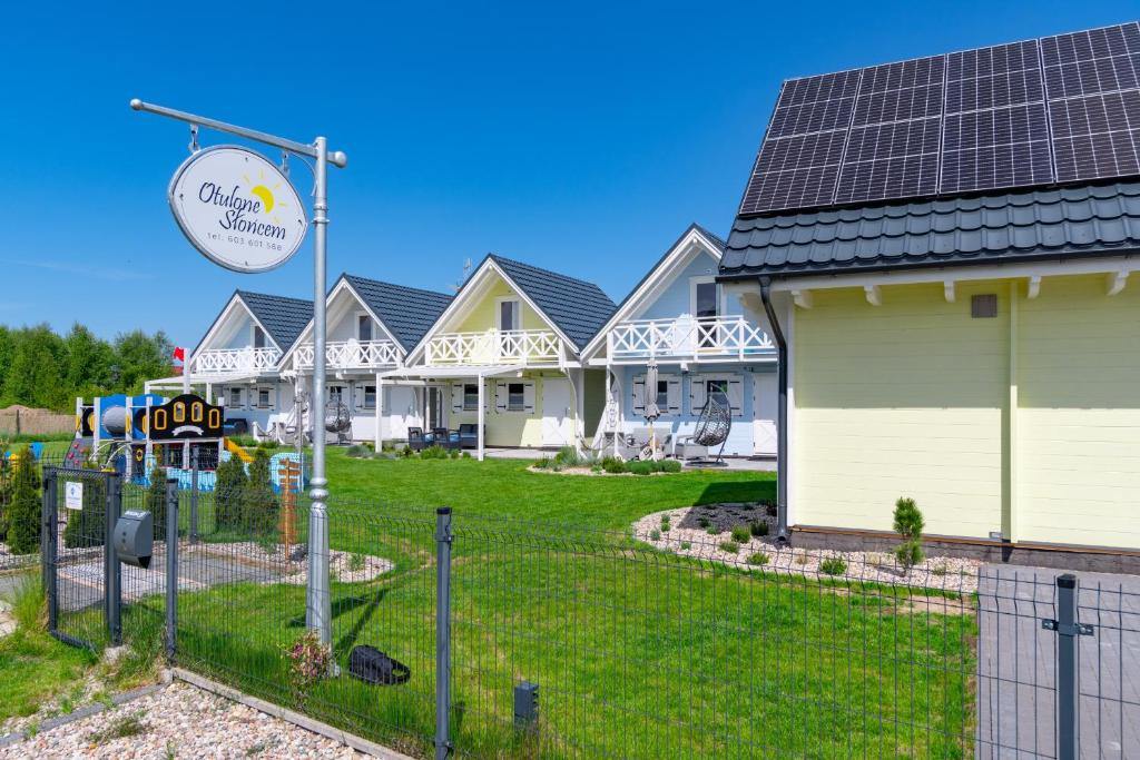 a row of houses with solar panels on them at Domki letniskowe Otulone Słońcem in Rowy