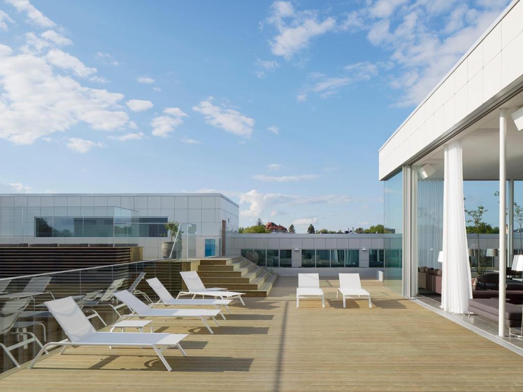 una terraza con tumbonas blancas en un edificio en PM & Vänner Hotel, en Växjö