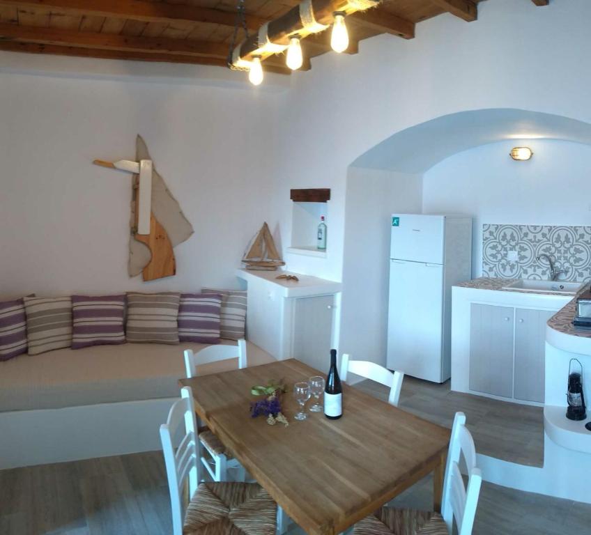 a kitchen and dining room with a table and a couch at Milos By The Sea - Eco House in Areti