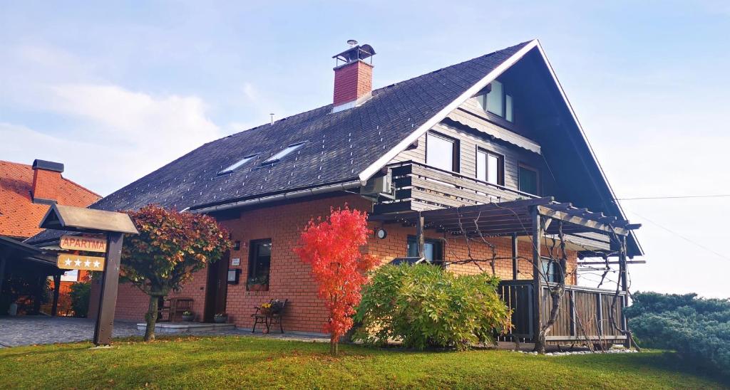 a large house with a gambrel roof at Apartments Janjusevic in Bled