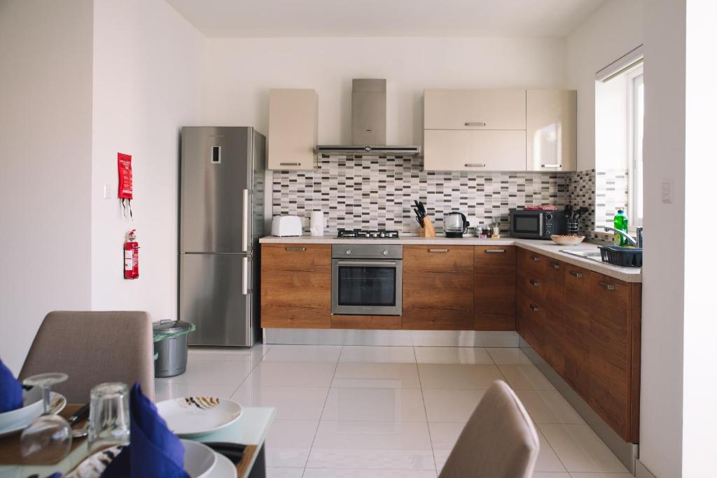 una cucina con armadietti in legno ed elettrodomestici in acciaio inossidabile di Modern 3 bedroom with AC apartment a Żabbar