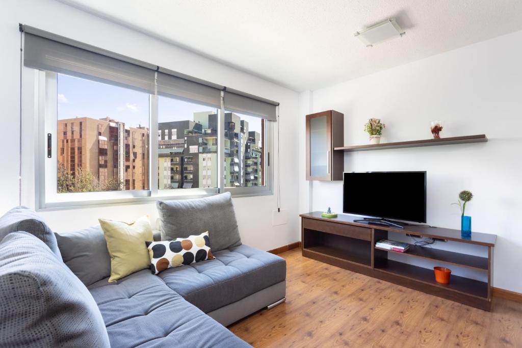 ein Wohnzimmer mit einem Sofa und einem Flachbild-TV in der Unterkunft Home2Book Bright Center Apartment Santa Cruz in Santa Cruz de Tenerife