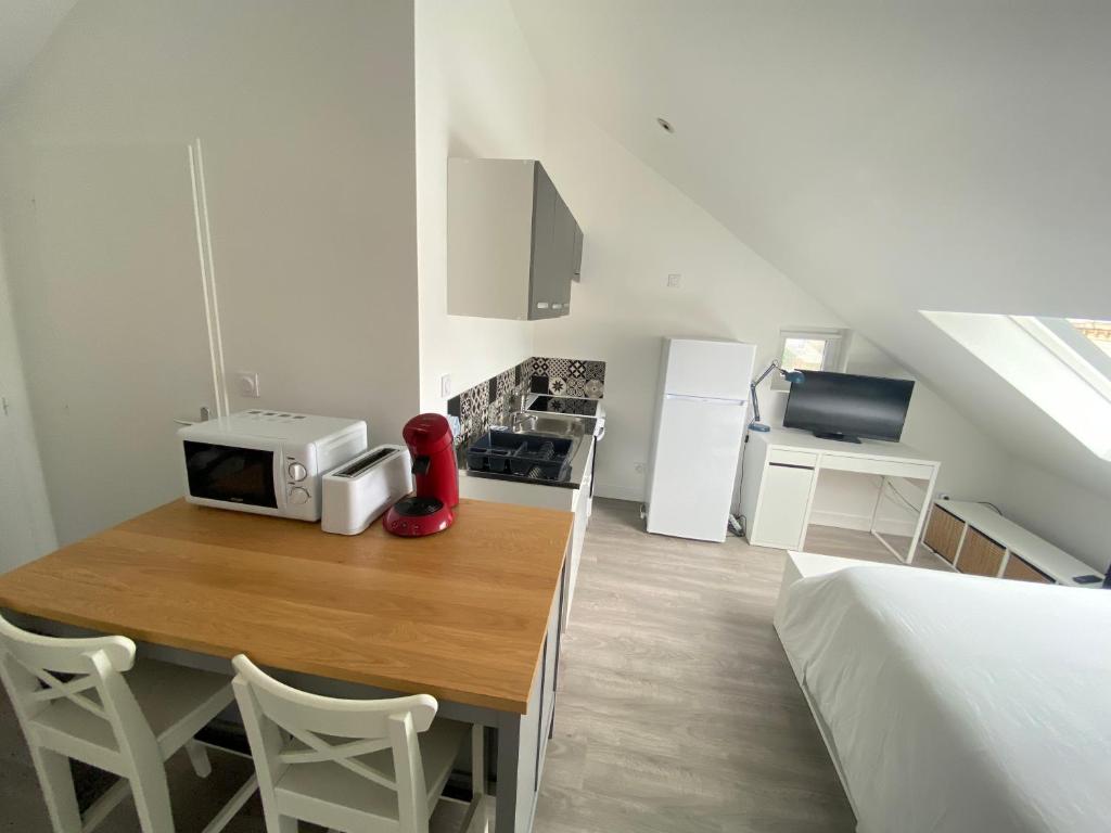 une petite cuisine avec une table et un four micro-ondes. dans l'établissement Vivez l'Echappée mer - 4 chemins - St Vincent - Plage, au Havre