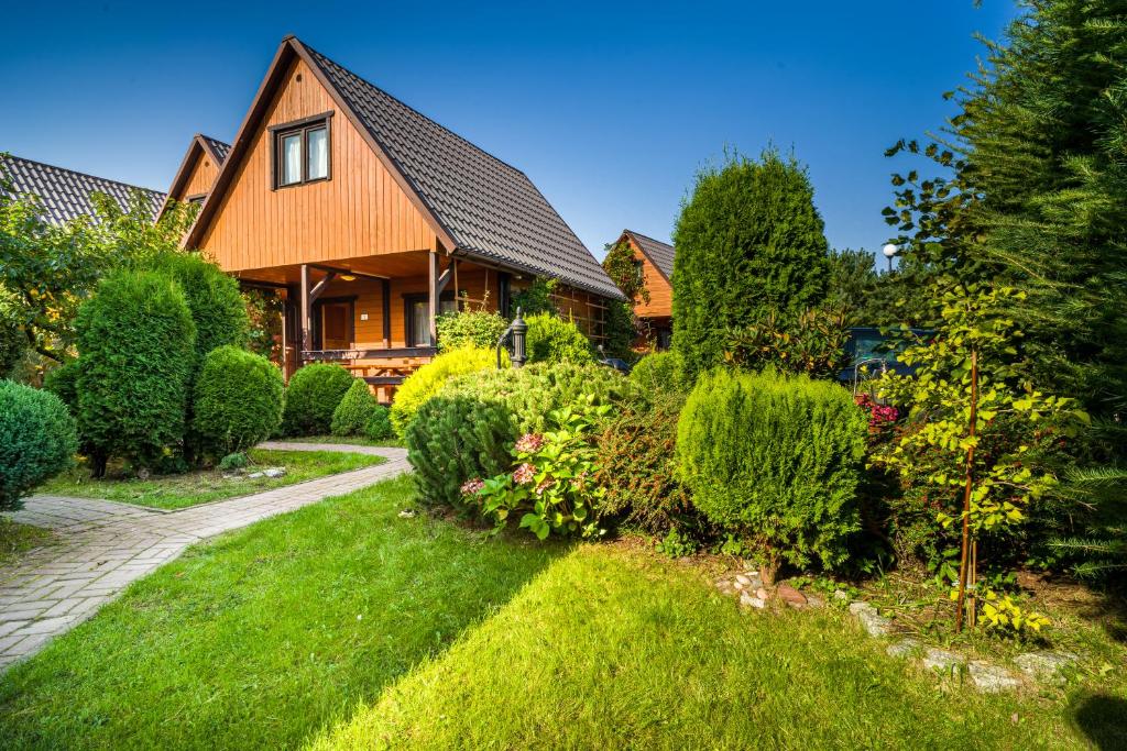 a house with a garden in front of it at Ośrodek Wypoczynkowy KLIF in Gąski