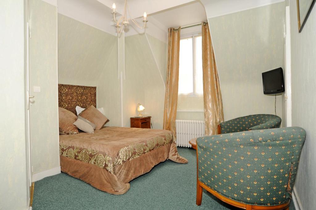 a hotel room with a bed and a chair at Hotel La Tour in Sully-sur-Loire