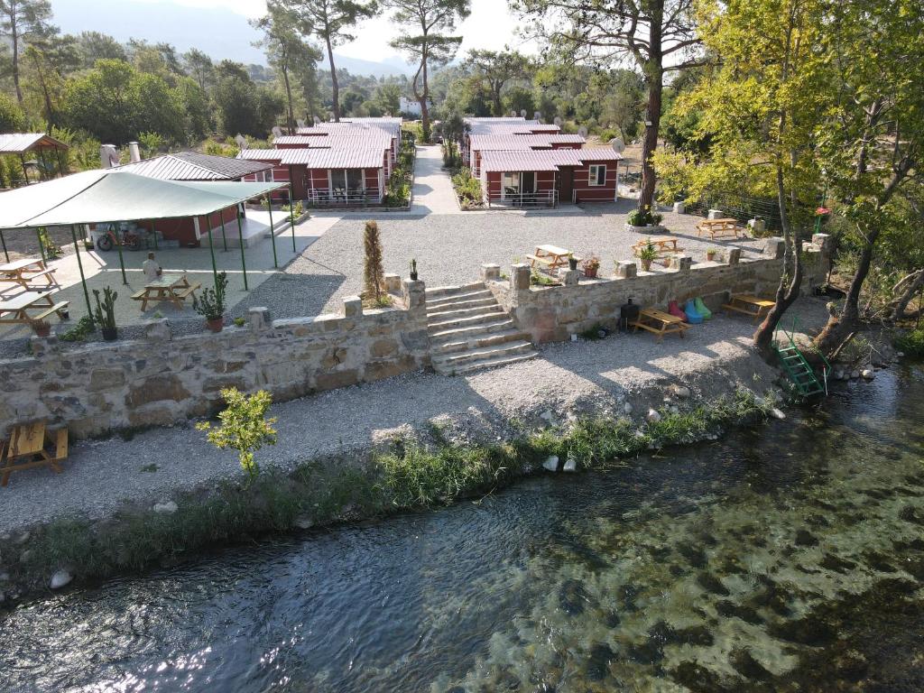 a river with tables and chairs next to a river at Kanyon Yaşam Evleri in Manavgat